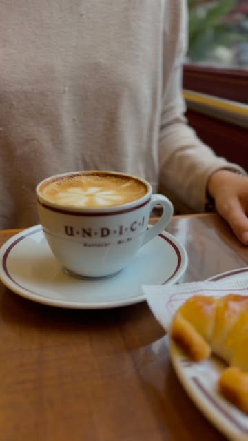 Café con leche en taza con el logo de Undici y una medialuna