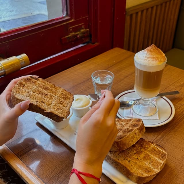 Tostadas con manteca y un cortado con espuma junto a la ventana de Undici